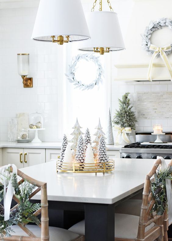 whitewashed evergreen wreaths, a mini Christmas tree, candles, ornaments and a white Christmas tree centerpiece