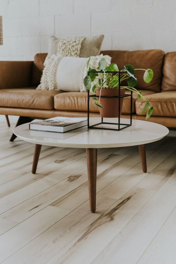 A beautiful and timeless mid century modern coffee table with a white round tabletop and rich stained tapered legs is a gorgeous idea to rock