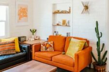 a boho living room with a black leather sofa, a modern orange loveseat, a low table and potted cacti feels warm and cool