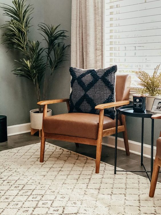 a classic mid-century modern brown leather chair with a boho pillow is a lovely addition to a mid-century modern sapce