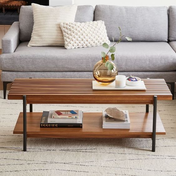 A cool wooden coffee table with two tabletops   a slab and a sleek one and tall black legs is a stylish and functional idea to rock