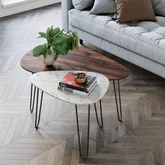 a duo of mid-century modern coffee tables, with a rich-stained wood and white stone tabletops and hairpin legs is cool