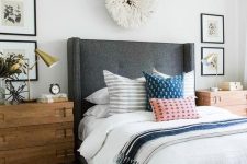 a grey upholstered bed with a curved headboard and rough wooden nightstands for a cozy feel