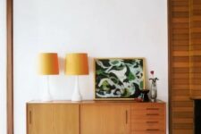 a light-stained amber-colored sideboards with doors and drawers on tall legs is a cool idea for a mid-century modern space