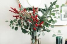 a lovely Christmassy arrangement with eucalyptus, holly berries and cranberries is a cool centerpiece, too