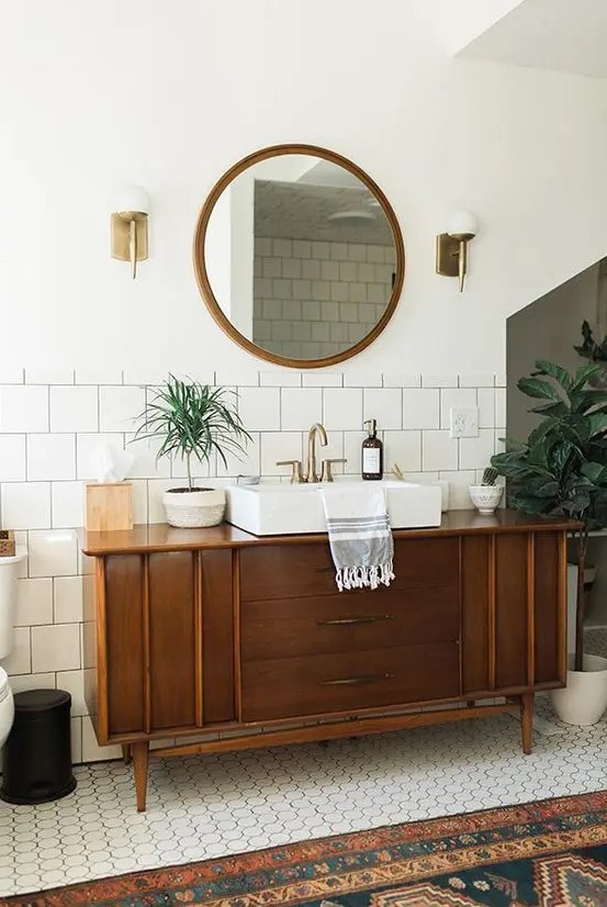 A mid century modern bathroom finished off with a stained cabinet that is a vanity that provides storage space