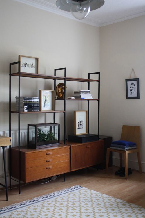 a mid-century modern storage unit with two cabinets in the lower part and open shelves in the upper part