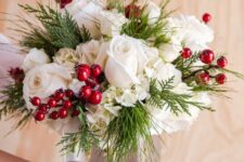 a pretty and simple cranberry Christmas centerpiece of white roses and hydrangeas, greenery and cranberries is a cool idea