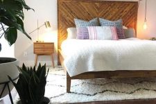 a reclaimed wooden bed with an oversized headboard and matching nightstands for a cozy feel in the space