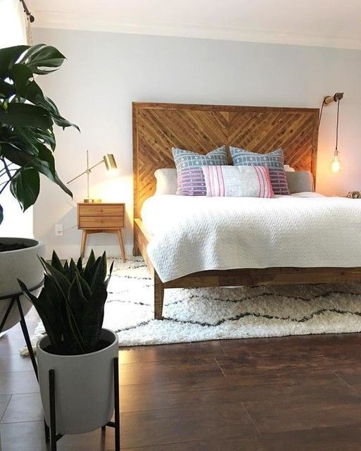 a reclaimed wooden bed with an oversized headboard and matching nightstands for a cozy feel in the space