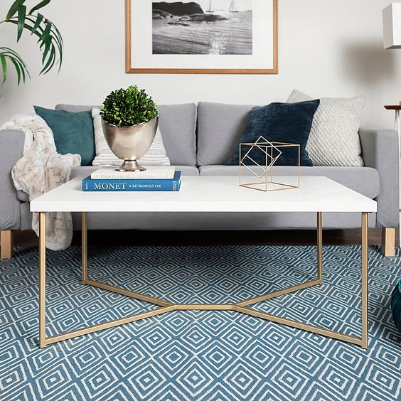 a refined mid-century modern coffee table with gilded legs and a white tabletop is a lovely idea for a Scandi living room, too