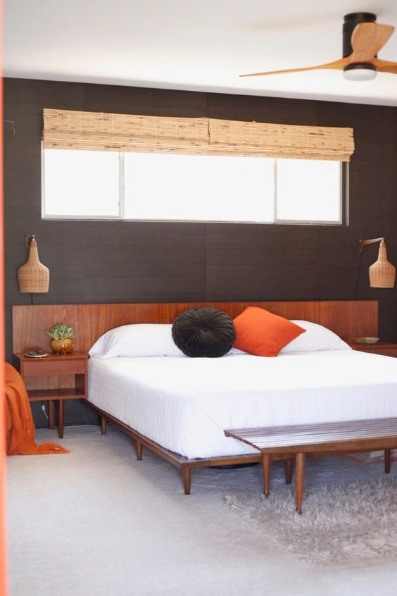 a rich stained mid-century modern bed, matching nightstands and a bench for creating a cozy bedroom