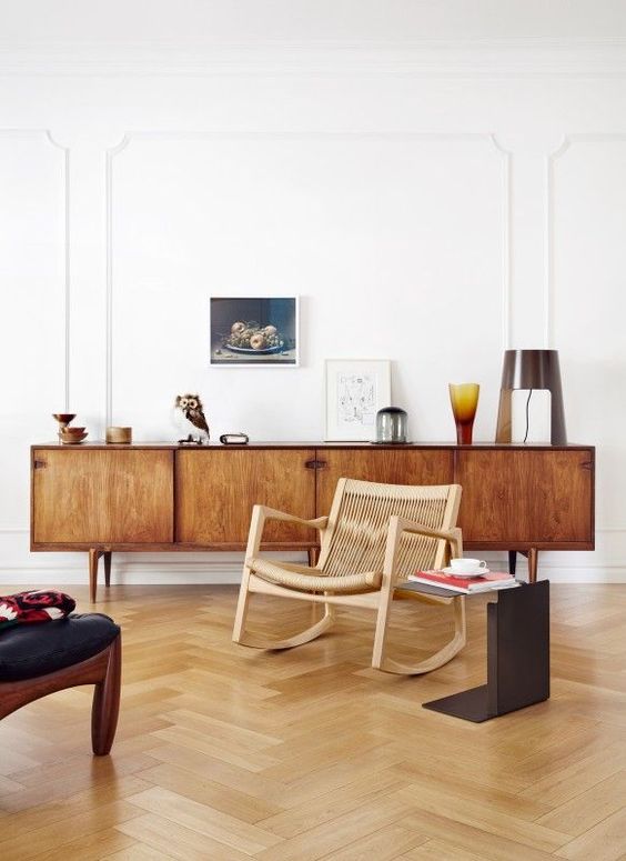 A rich stained mid century modern sideboard with doors and cutout handles is a classic solution that suits many spaces