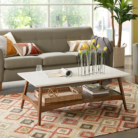 A simple and cool two tiered coffee table with a white and a stained tabletop is a chic and functional idea to rock in a mid century modern living room