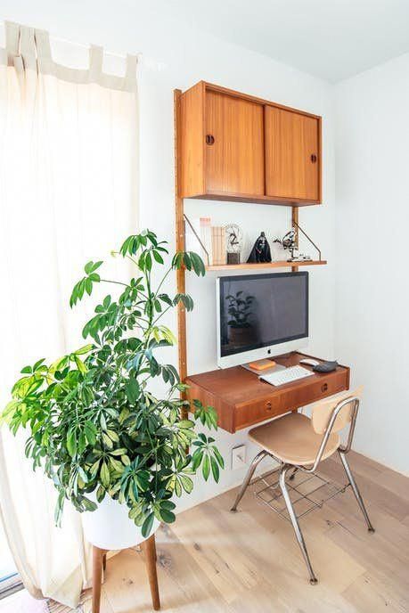 A small wall mounted unit with a closed cabinet, a shelf and a drawer that is used as a small desk