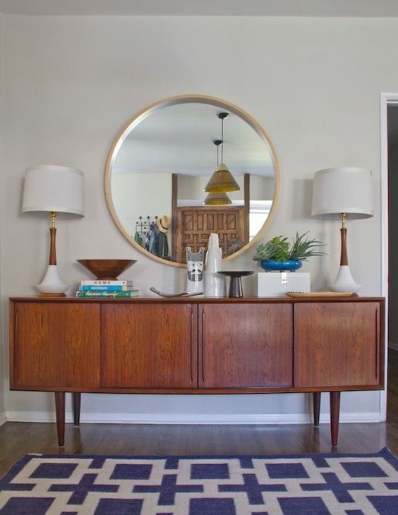 A stained credenza as part of a stylish mid century modern living room or dining space with matching table lamps
