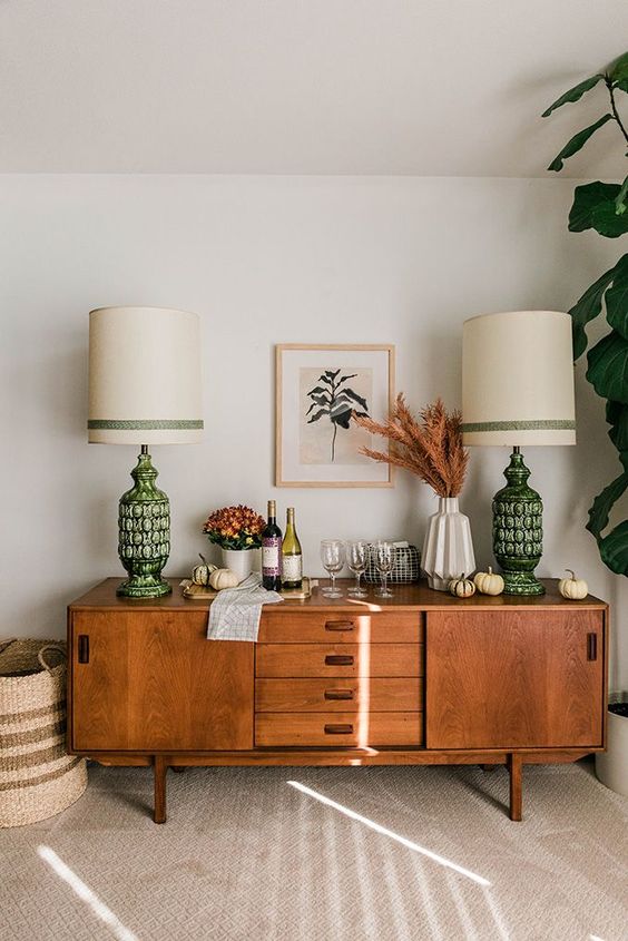 A stylish rich stained sideboard as a home bar, with sliding doors and drawers with cutout handles is a lovely idea for a mid century modern space