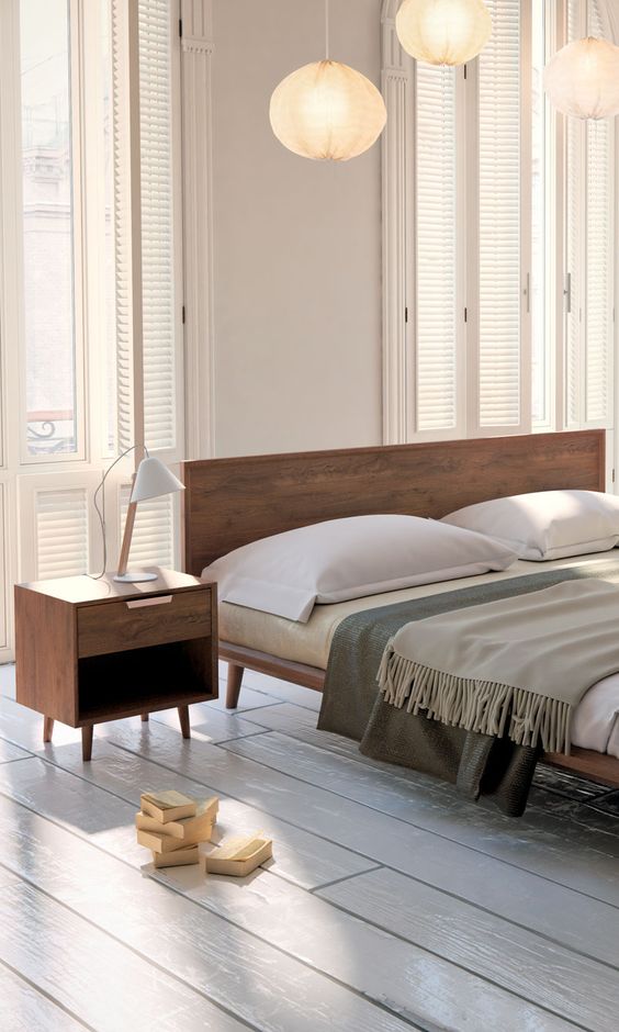 A stylish rich stained wooden bed and nightstands for a welcoming mid century modern bed
