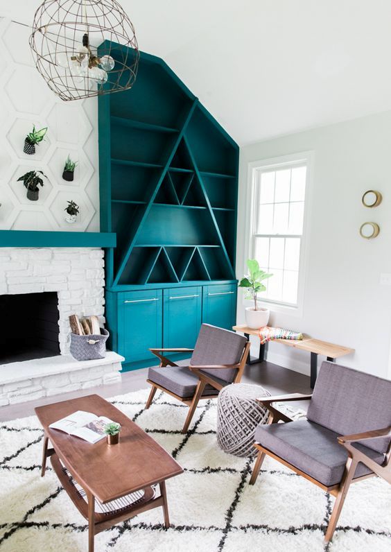A turquoise mid century modern bookcase with geometric elements, with open and closed storage spaces