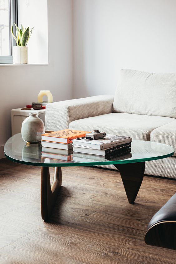 an elegant and stylish mid-century modern coffee table with curved wooden legs and a triangle tabletop is a beautiful idea