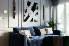 an elegant living room with dove grey walls, a modern navy sofa, a black chair, a chic artwork and some gold and brass touches for a chic look