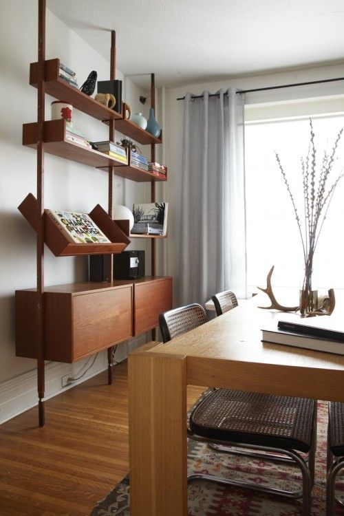 an elegant storage unit with a slanted shelf, some open shelves and two cabinets in the lower part