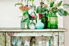 blue and green vintage bottles with super bright and colorful blooms and greenery is chic and cool decor