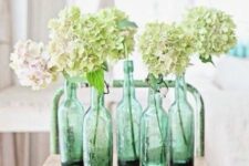 green vintage bottles with blush and green hydrangeas is a cool spring-like decor idea