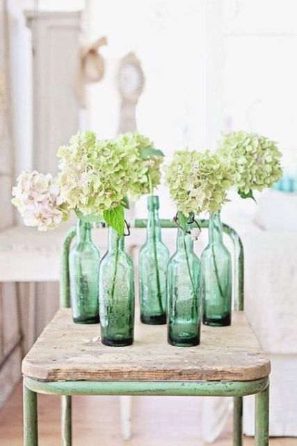 Green vintage bottles with blush and green hydrangeas is a cool spring like decor idea