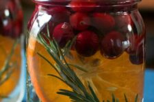 jars with rosemary, citrus slices and cranberries are great to style your space for the holidays