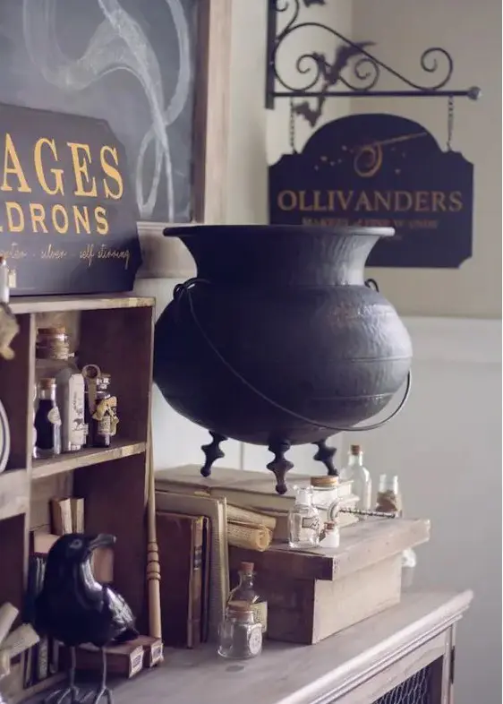 lovely vintage Halloween decor inspired by Harry Potter books with a wooden shelf, vintage apothecary bottles and a bird, a witch's cauldron, some signs