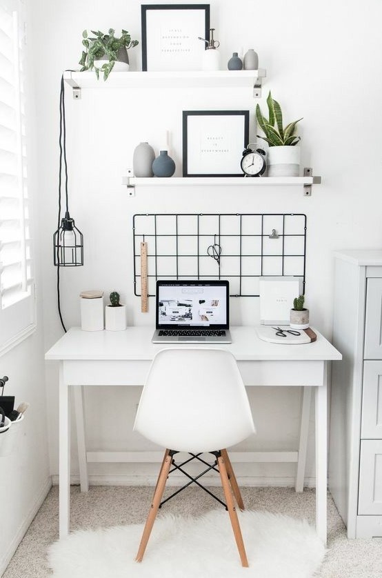 a Nordic home office nook done in white and accented with a black grid on the wall, a pendant lamp and chair elements