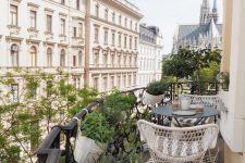 a Scandinavian balcony with a striped rug, white chairs and a black coffee table, potted greenery and fantastic views of Vienna