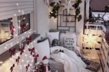 a cozy little balcony with a light tree with red bows, some candle lanterns, a star lamp, stars and greenery on the wall and fur and knit textiles