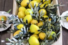 a dough bowl centerpiece with willow and lemons is a bright and chic idea for spring