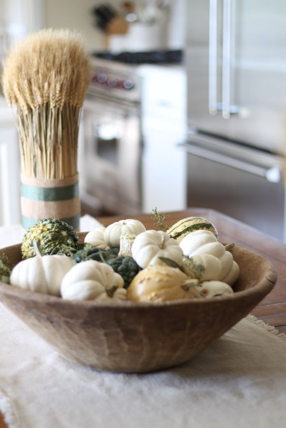 a dough bowl with various pumpkins is an easy and cool fall centerpiece