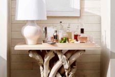 a home bar placed on the whitewashed driftwood is a cool and bold idea with a coastal feel