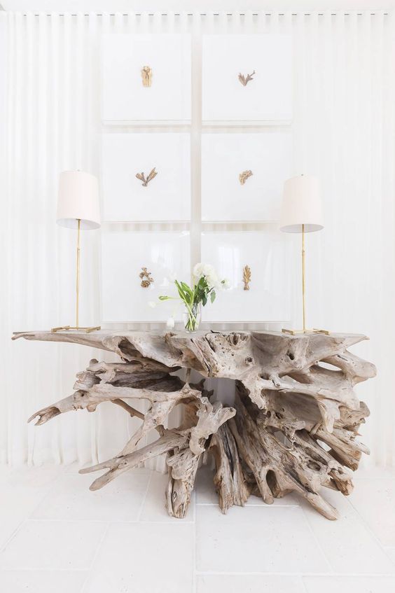a large and dimensional console table made of driftwood is a stunning statement for a beachy entryway