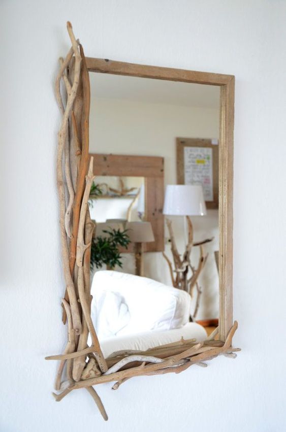 a mirror partly decorated with driftwood is a cool and chic idea to make your space relaxed and beachy