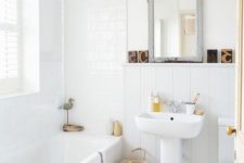 a neutral and cute bathroom with a Nordic feel, a basket for storage, a vintage mirror and whiet tiles