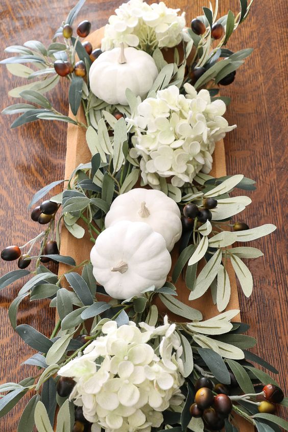 a simple neutral fall DIY centerpiece using a vintage rustic dough bowl, hydrangeas, olive branches and milk paint pumpkins