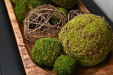 a simple rustic centerpiece with a dough bowl, moss and twine balls is a natural decoration