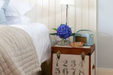 a small wooden chest with vintage numbers and some more vintage pieces on top is a lovely idea of a nightstand, with a story