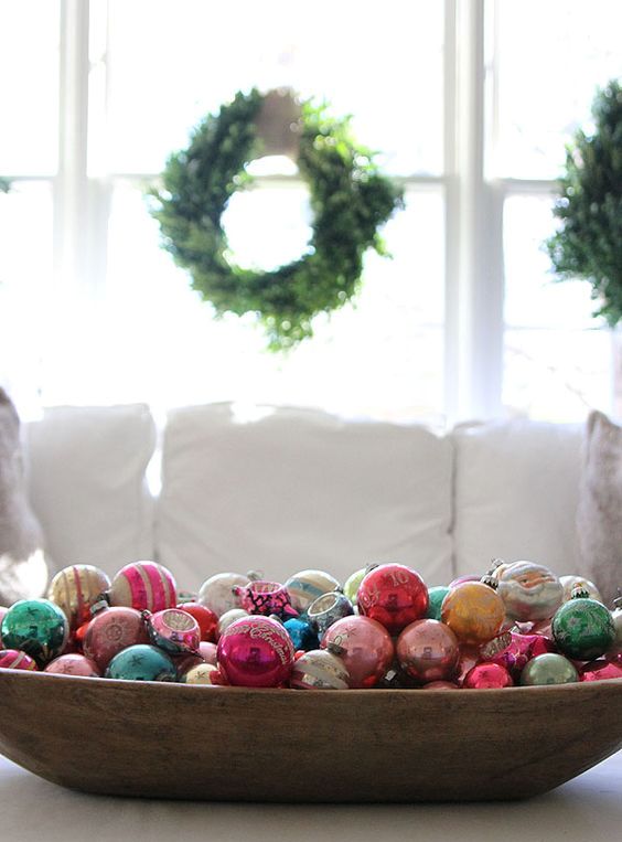 a stylish Christmas decoration of a vintage dough bowl and colorful vintage Christmas ornaments