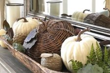 a stylish rustic fall decoration with a dough bowl, real and fake pumpkins of various materials plus greenery