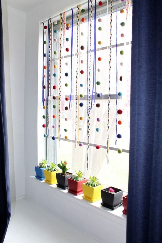 colorful ribbons and pompom garlands plus colorful planters to make the modern space very bold