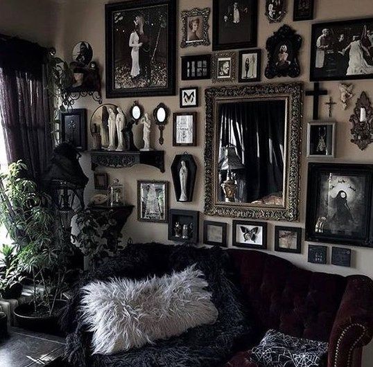 a Gothic-inspired living room with refined black furniture, a gallery wall with artworks and mirrors and potted greenery