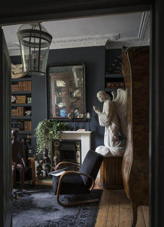 a Gothic living room with a tiled fireplace, molding, black furniure, unique artworks and greenery in pots