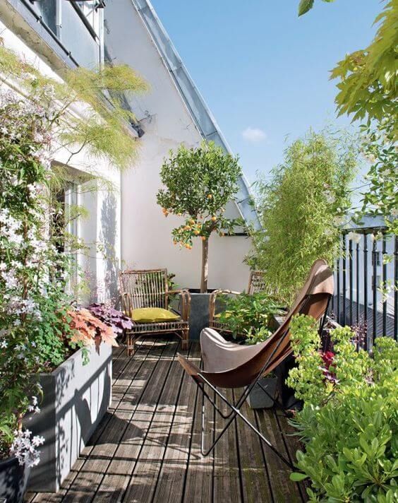 a bright and welcoming terrace with rattan and wicker chairs with bright upholstery, potted greenery and blooms