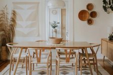 a modern boho dining space in neutrals, with a wooden dining set, printed textiles, decorative baskets and pampas grass